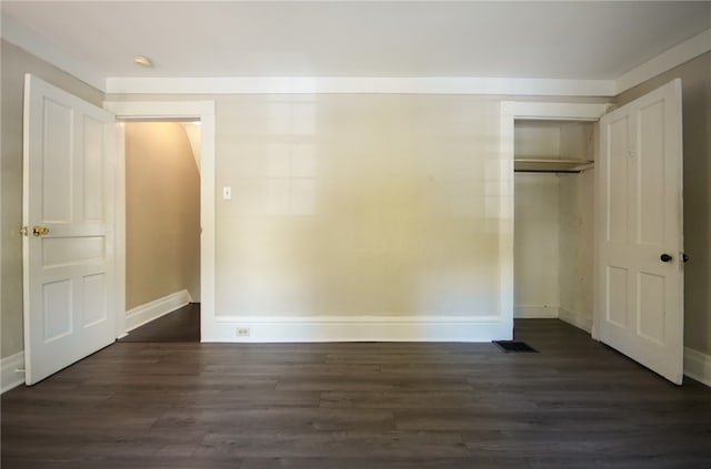 unfurnished bedroom with a closet and dark hardwood / wood-style floors