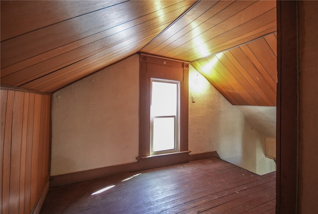 additional living space with dark wood-type flooring, wooden ceiling, vaulted ceiling, and wooden walls