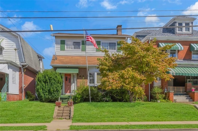 view of front of house with brick siding and a front lawn