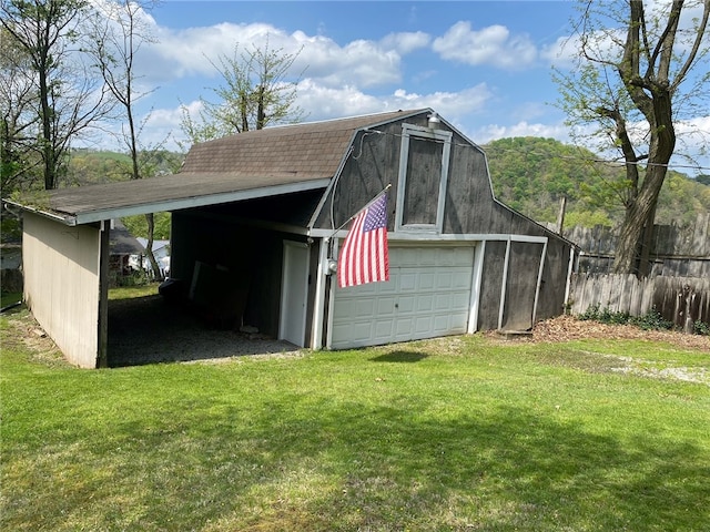 garage featuring a carport and a lawn