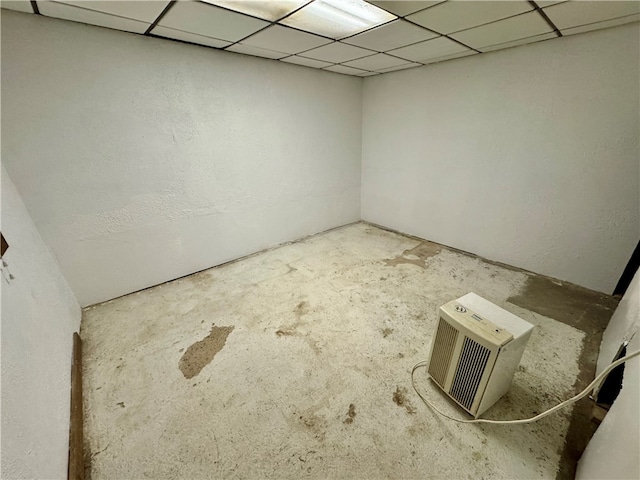 empty room featuring a paneled ceiling and concrete floors