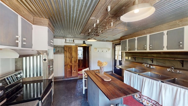 kitchen featuring wood counters, sink, extractor fan, and range