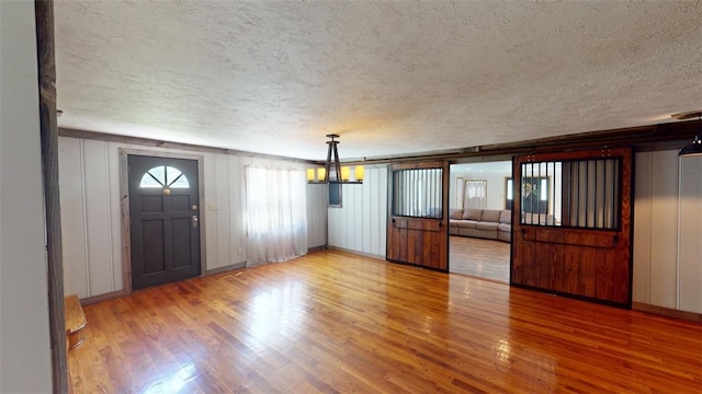 foyer entrance with a textured ceiling and hardwood / wood-style floors