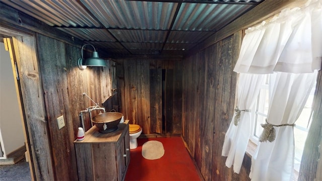 hallway featuring sink and wooden walls