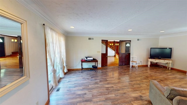 living room featuring crown molding, a textured ceiling, and wood-type flooring