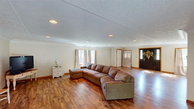 living room featuring a textured ceiling, a healthy amount of sunlight, hardwood / wood-style flooring, and crown molding