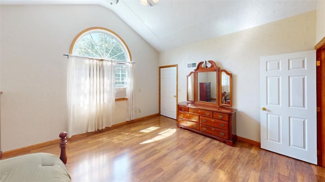 bedroom with lofted ceiling and light hardwood / wood-style floors