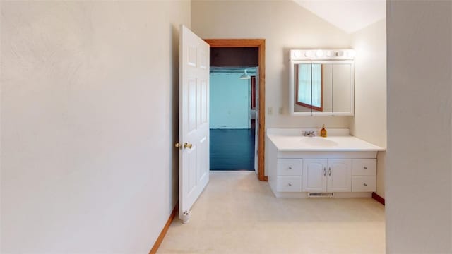 bathroom featuring vanity and lofted ceiling