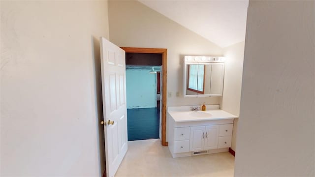 bathroom featuring vanity and lofted ceiling