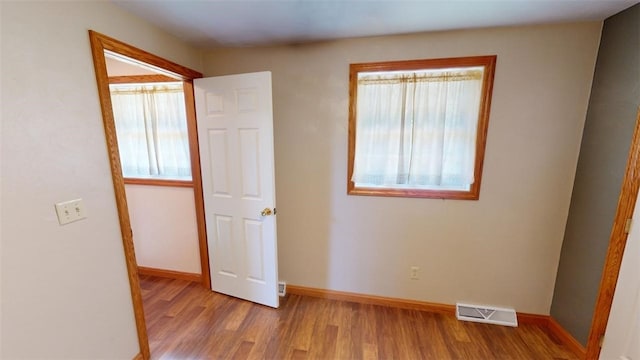 unfurnished bedroom with light wood-type flooring and multiple windows