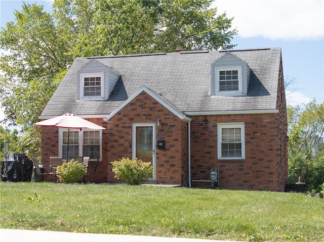 cape cod-style house with a front yard