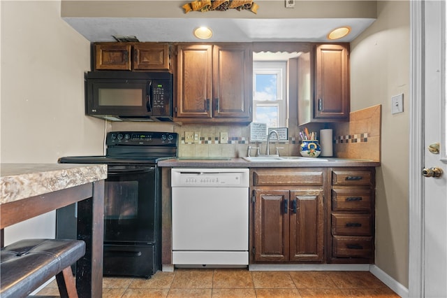 kitchen featuring black appliances, sink, light tile patterned floors, and decorative backsplash