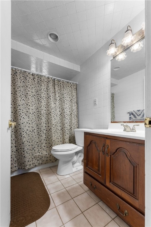 bathroom with vanity, curtained shower, tile patterned flooring, tile walls, and toilet