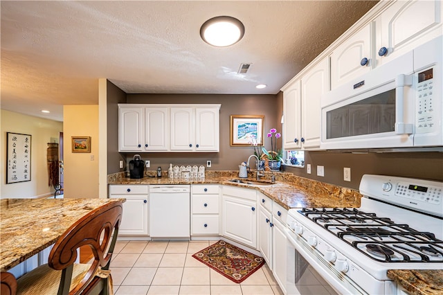 kitchen featuring white cabinets, white appliances, sink, and stone counters