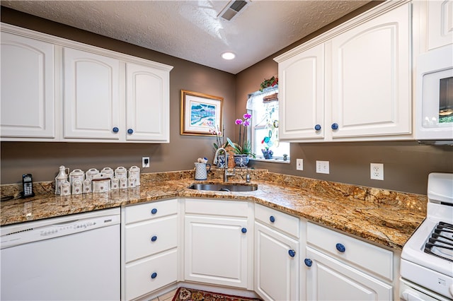 kitchen featuring white cabinets, white appliances, stone countertops, and sink