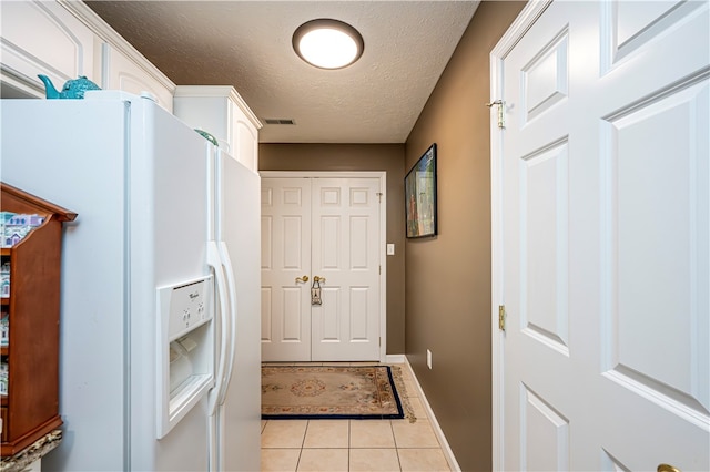 entryway featuring a textured ceiling and light tile patterned floors