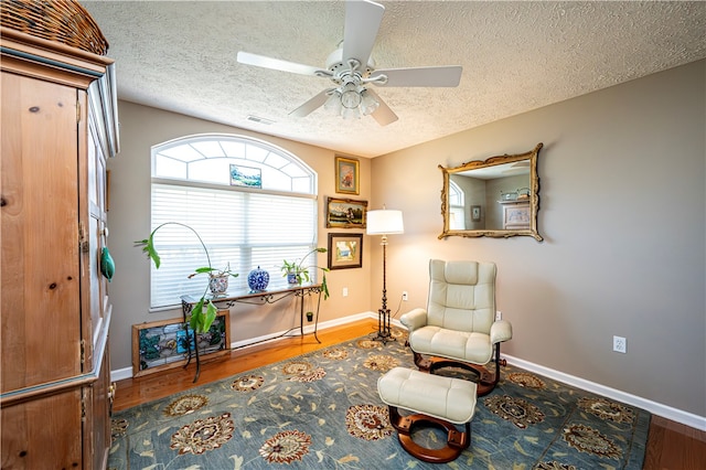 sitting room with a textured ceiling, ceiling fan, and hardwood / wood-style flooring