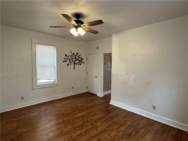 spare room with dark wood-type flooring and ceiling fan