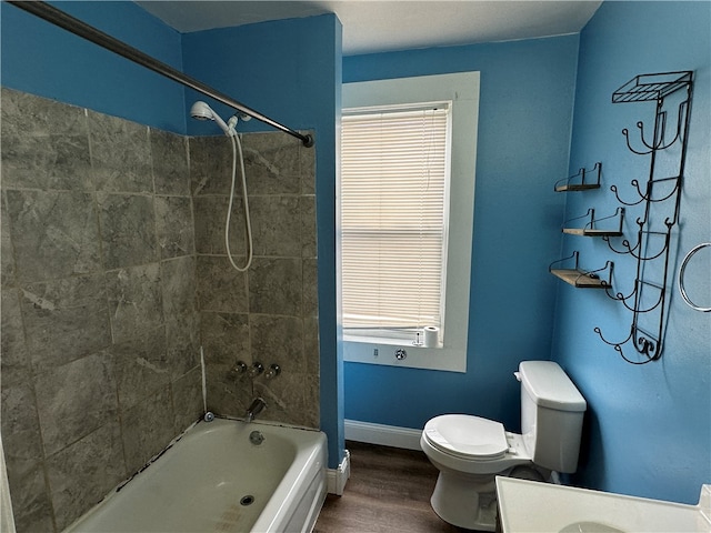 full bathroom with wood-type flooring, toilet, tiled shower / bath combo, and vanity