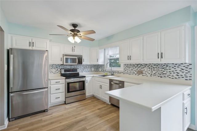 kitchen with ceiling fan, stainless steel appliances, sink, and decorative backsplash