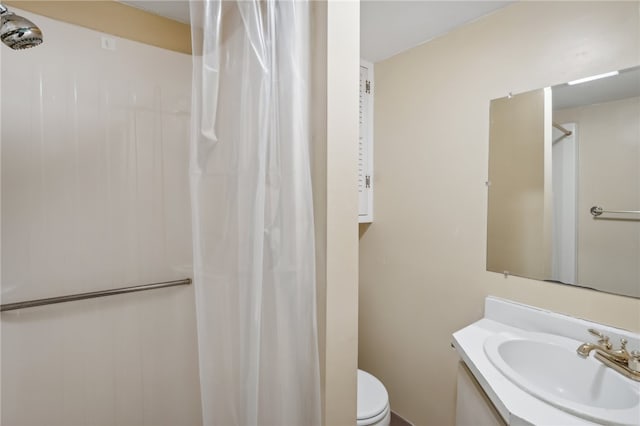 bathroom with walk in shower, toilet, and vanity