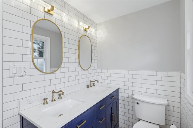 bathroom with tile walls, toilet, vanity, and decorative backsplash