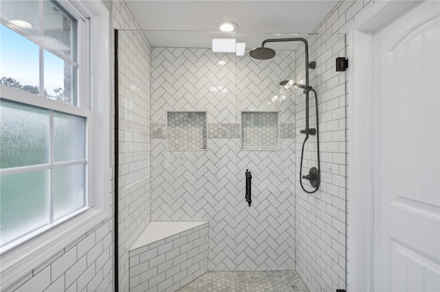 bathroom with a wealth of natural light and a shower with shower door