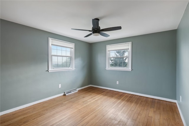 spare room featuring light wood-type flooring, a wealth of natural light, and ceiling fan