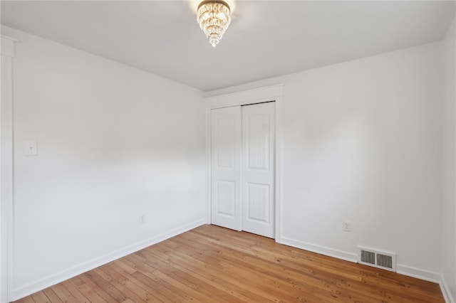 unfurnished bedroom with light wood-type flooring and a closet