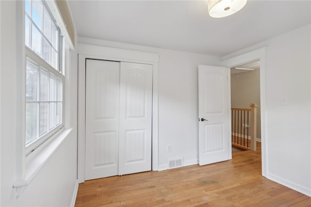 unfurnished bedroom featuring light hardwood / wood-style flooring and a closet