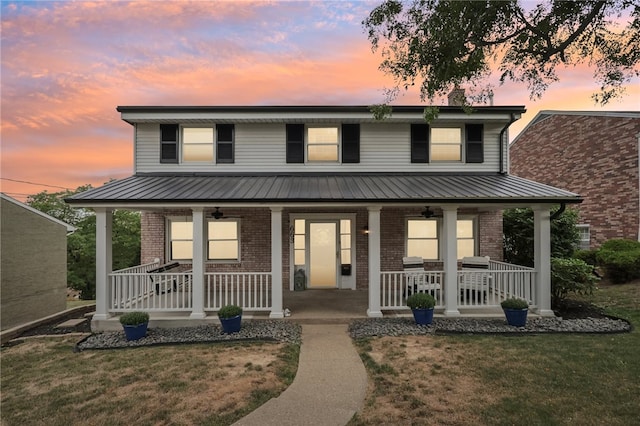 view of front facade with a porch and a lawn