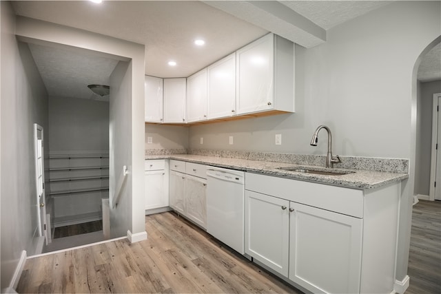 kitchen featuring white cabinets, dishwasher, light hardwood / wood-style floors, and sink