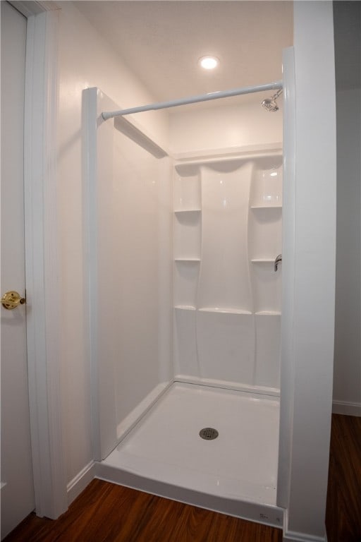 bathroom with hardwood / wood-style flooring and walk in shower