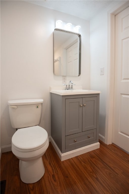 bathroom with vanity, toilet, and wood-type flooring