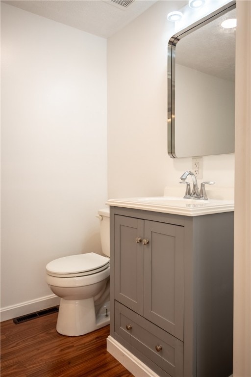 bathroom featuring vanity, toilet, and wood-type flooring