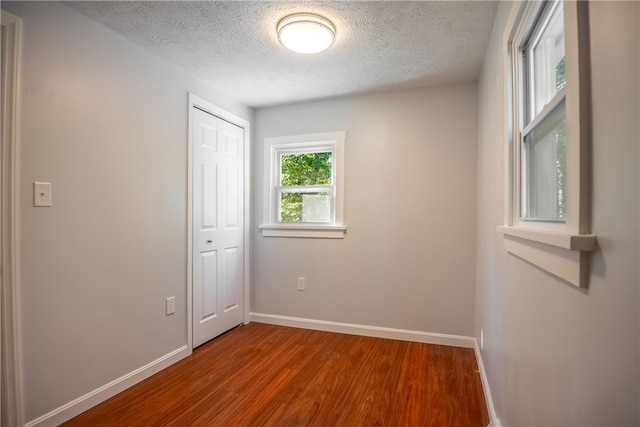 spare room featuring a textured ceiling and hardwood / wood-style floors