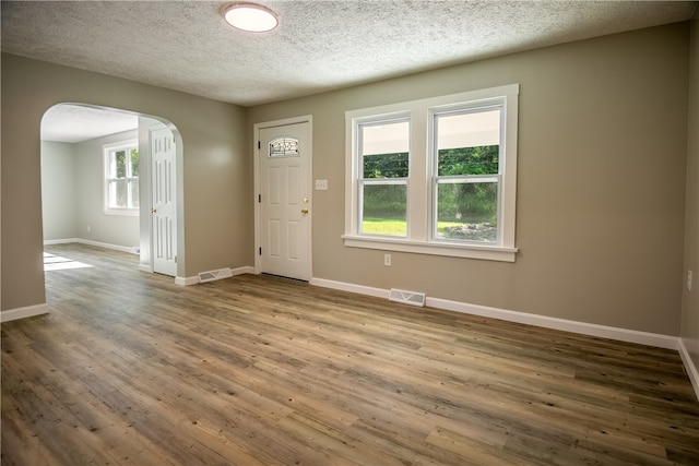 entryway with hardwood / wood-style floors and a textured ceiling