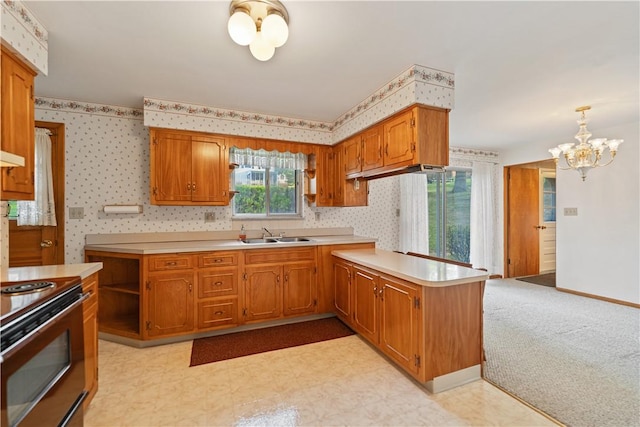 kitchen with sink, an inviting chandelier, pendant lighting, light colored carpet, and electric stove