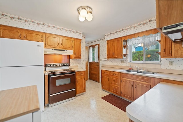 kitchen featuring white refrigerator, range with electric stovetop, and sink