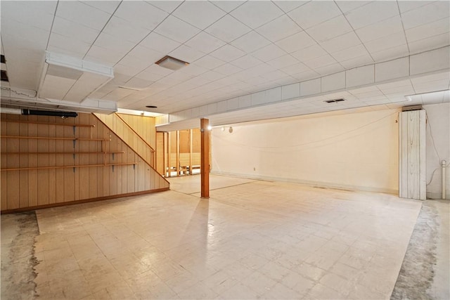 basement featuring wood walls