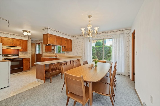 dining area featuring a chandelier and light carpet