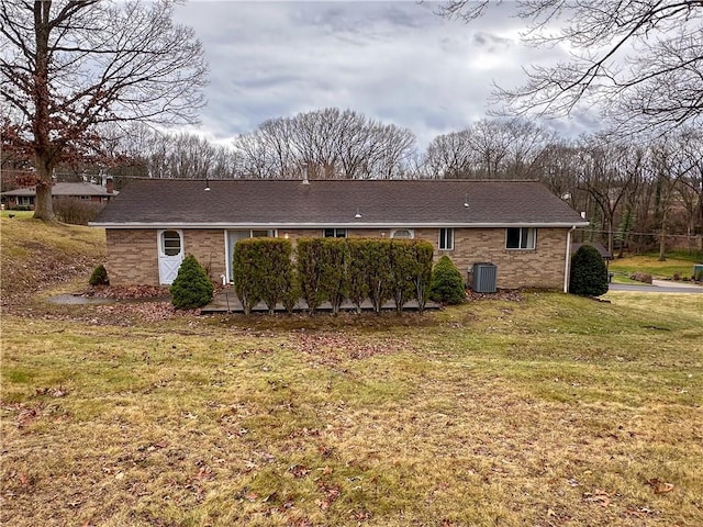 rear view of house featuring a yard and central AC unit