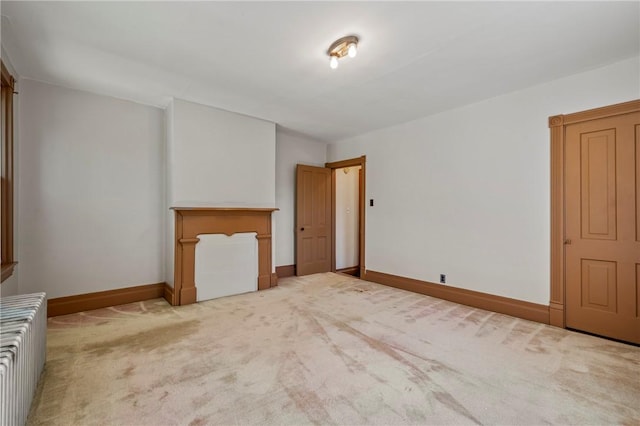 interior space with light colored carpet and radiator heating unit