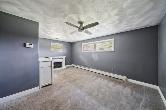 interior space with a baseboard radiator, ceiling fan, carpet, and a fireplace