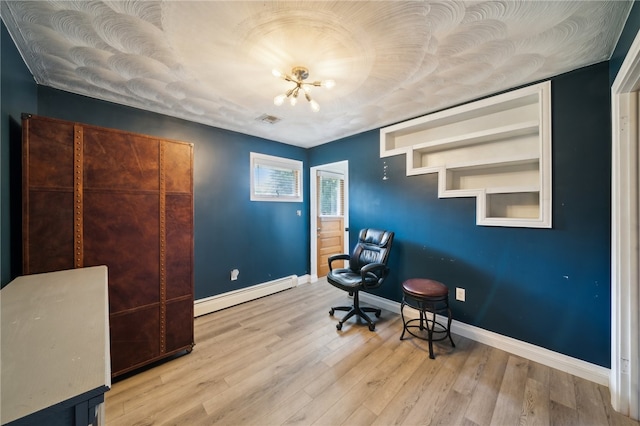 home office with a baseboard heating unit, a textured ceiling, and light hardwood / wood-style floors