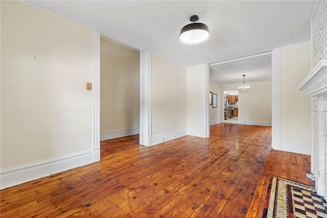 unfurnished living room featuring hardwood / wood-style floors and an inviting chandelier