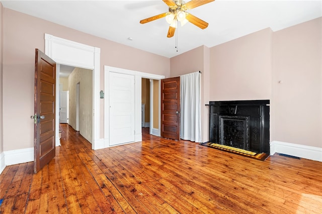 unfurnished living room with ceiling fan and hardwood / wood-style floors