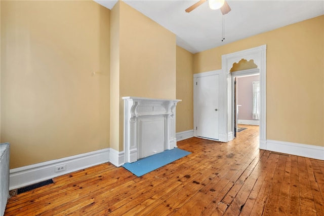 unfurnished living room with light wood-type flooring and ceiling fan