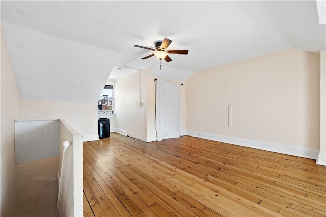 additional living space featuring lofted ceiling, light hardwood / wood-style flooring, ceiling fan, and a textured ceiling