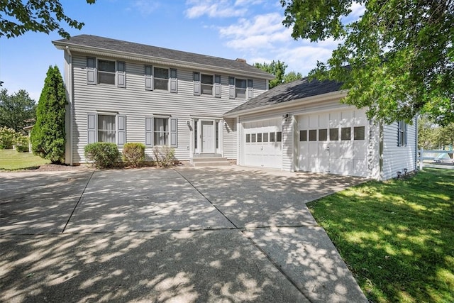 colonial home with a front yard and a garage